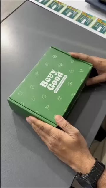 Green branded mailer box being inspected