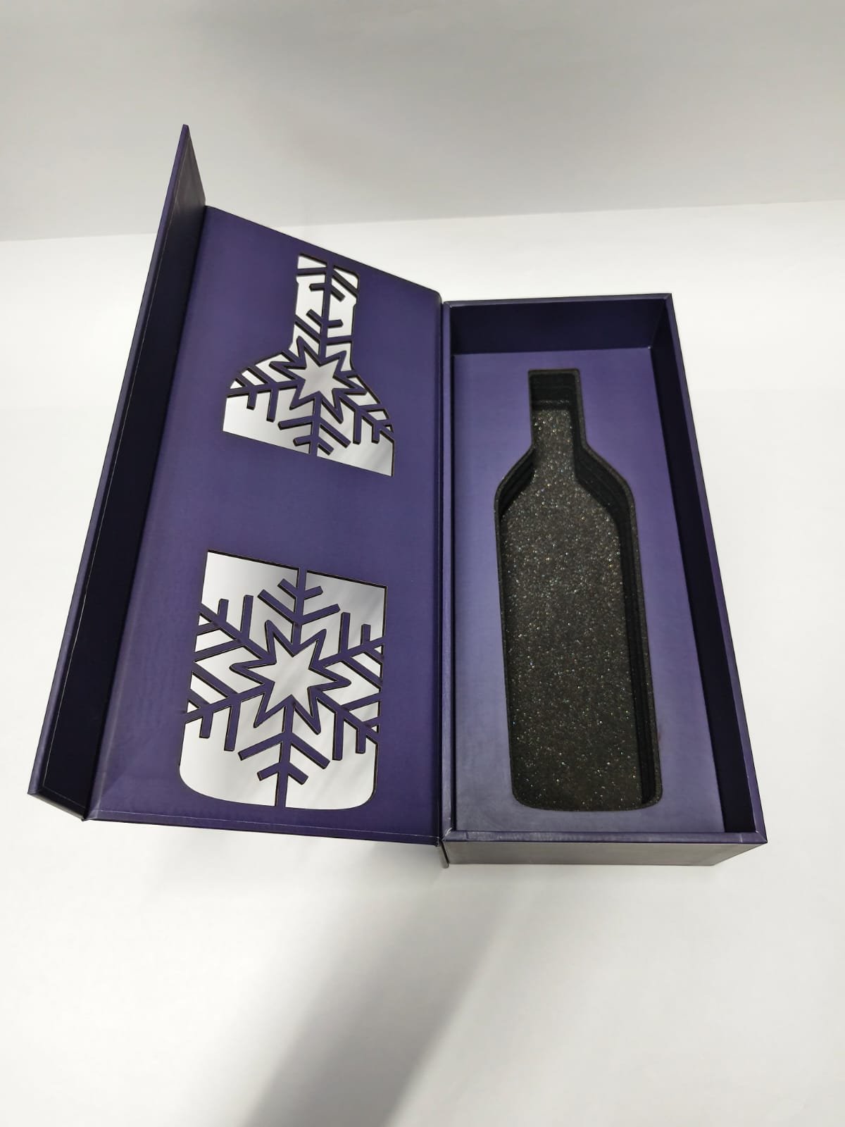 Open purple book-style bottle box with a fitted dark cavity