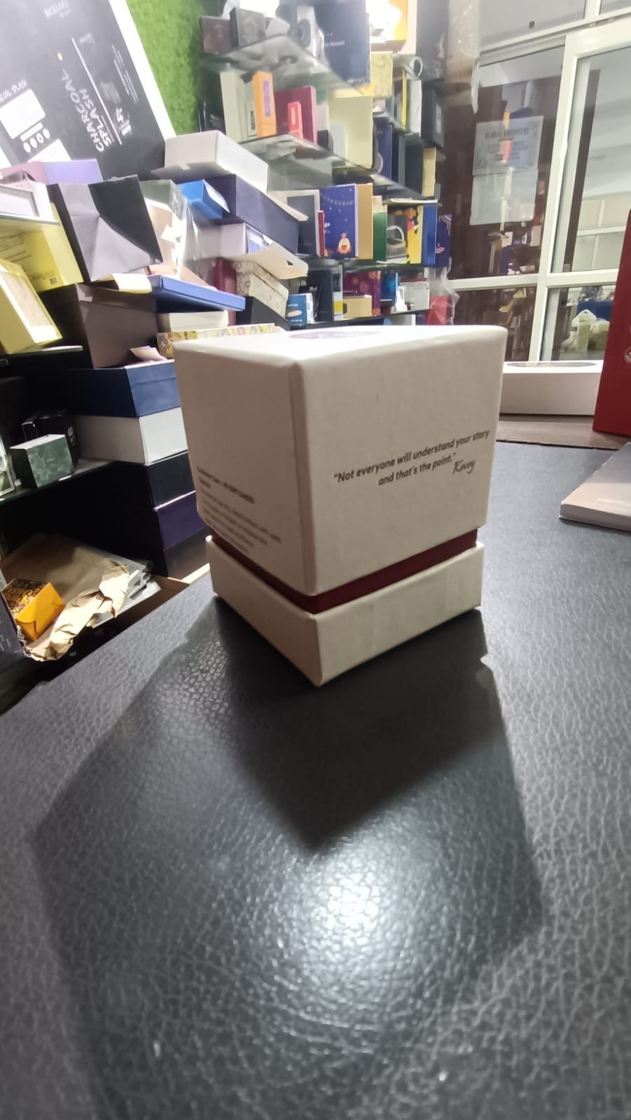 Ivory rectangular presentation box with a lift-off lid and a burgundy shoulder reveal above the base.